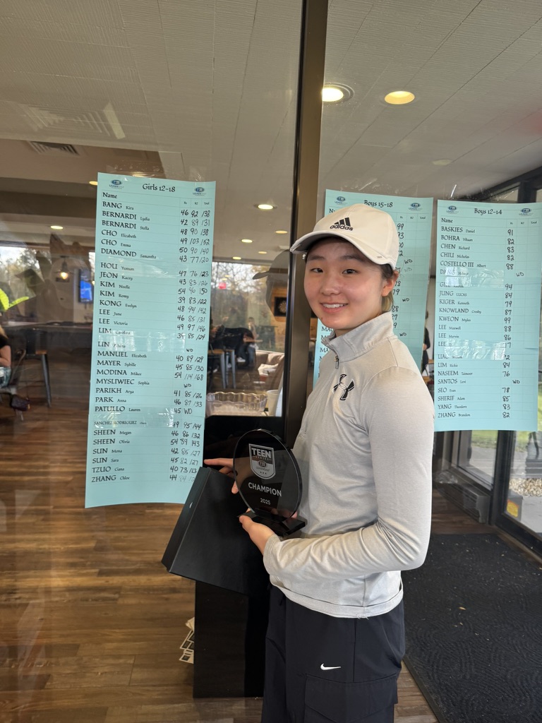 Ciana after a junior golf tournament, holding a champion trophy