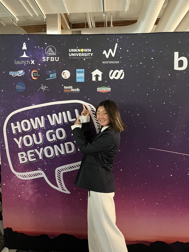 Ciana at an event backdrop with the tact & tech logo